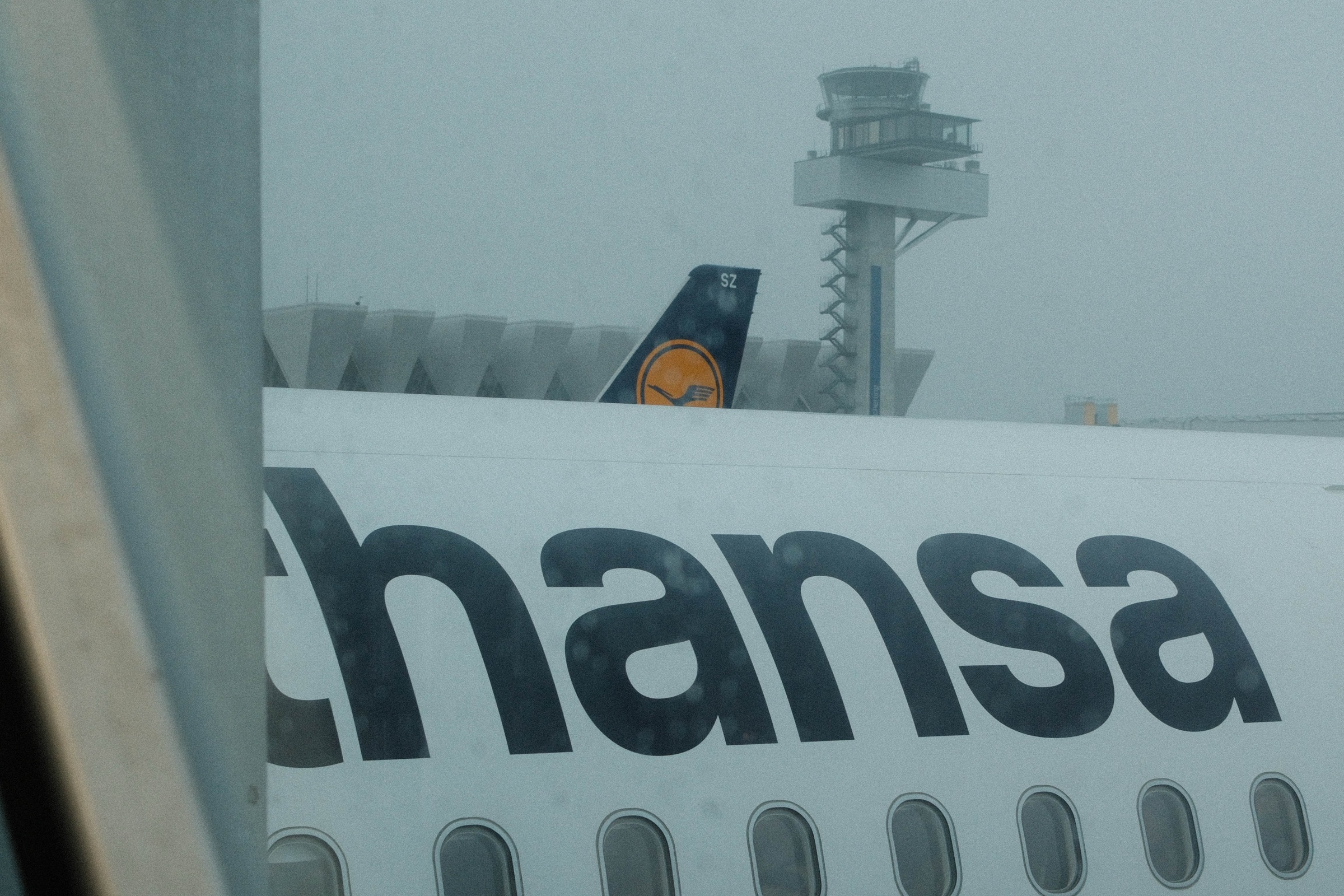An aircraft seen through a misted airport terminal window