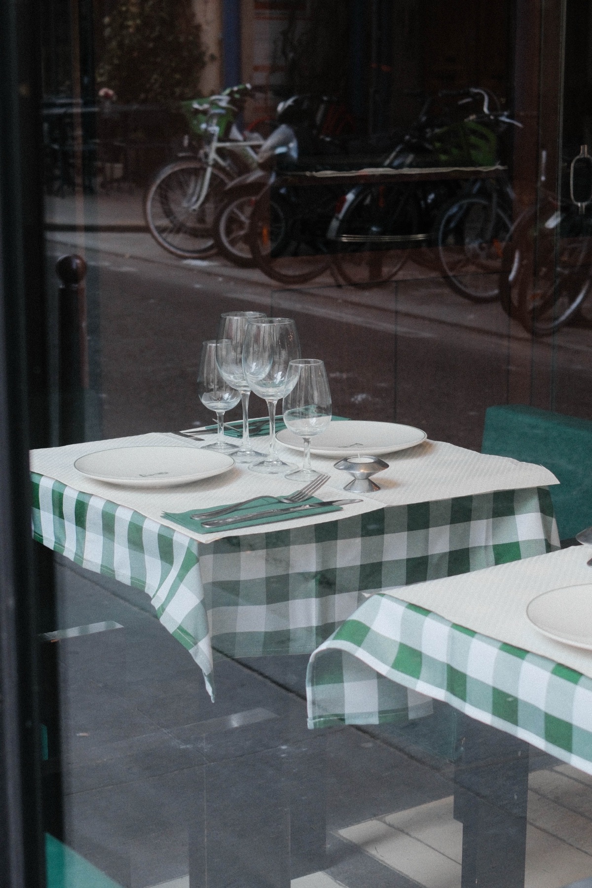 An empty café table seen through street reflections