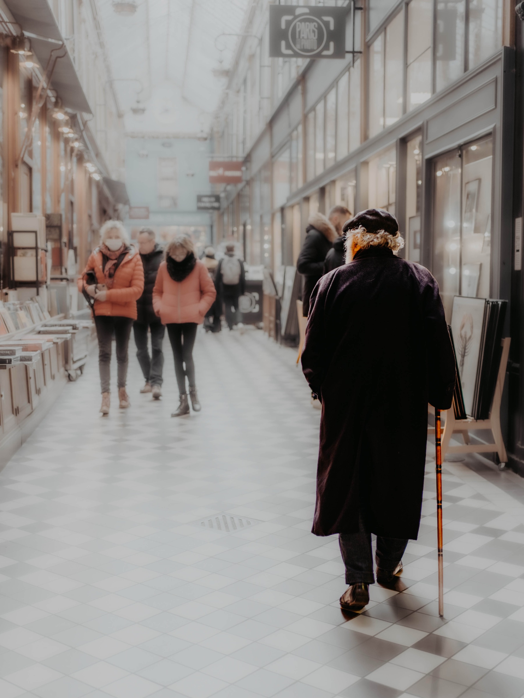 A solitary figure walking through a bright shopping arcade