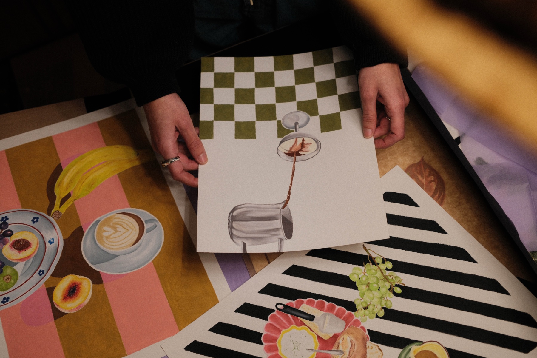 Hands arranging graphic cards across a colourful table