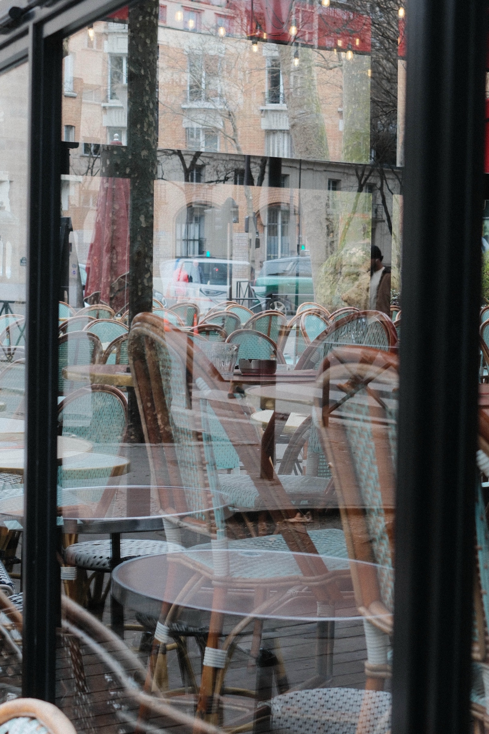 Street reflections layered across a city newsstand