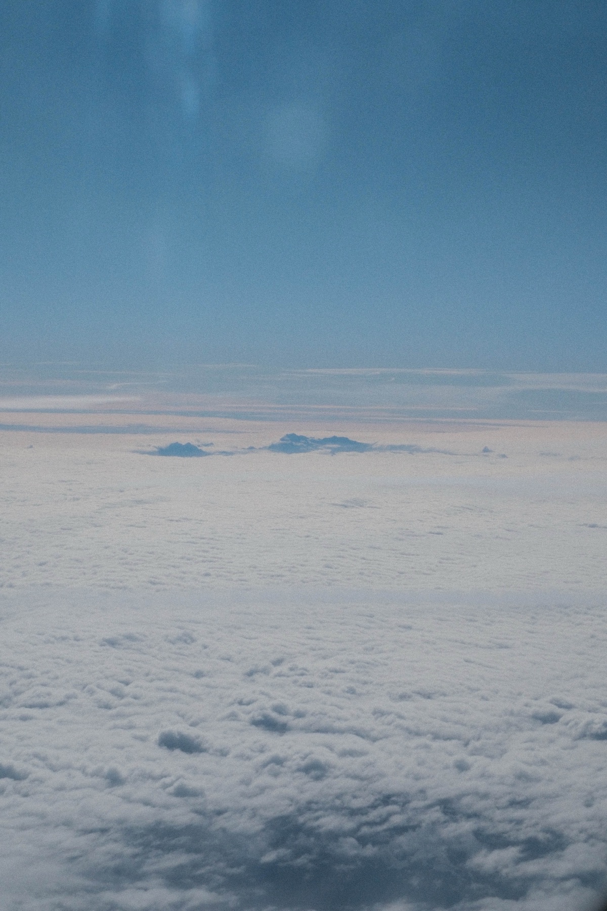 A pale horizon of sea, cloud and distant land