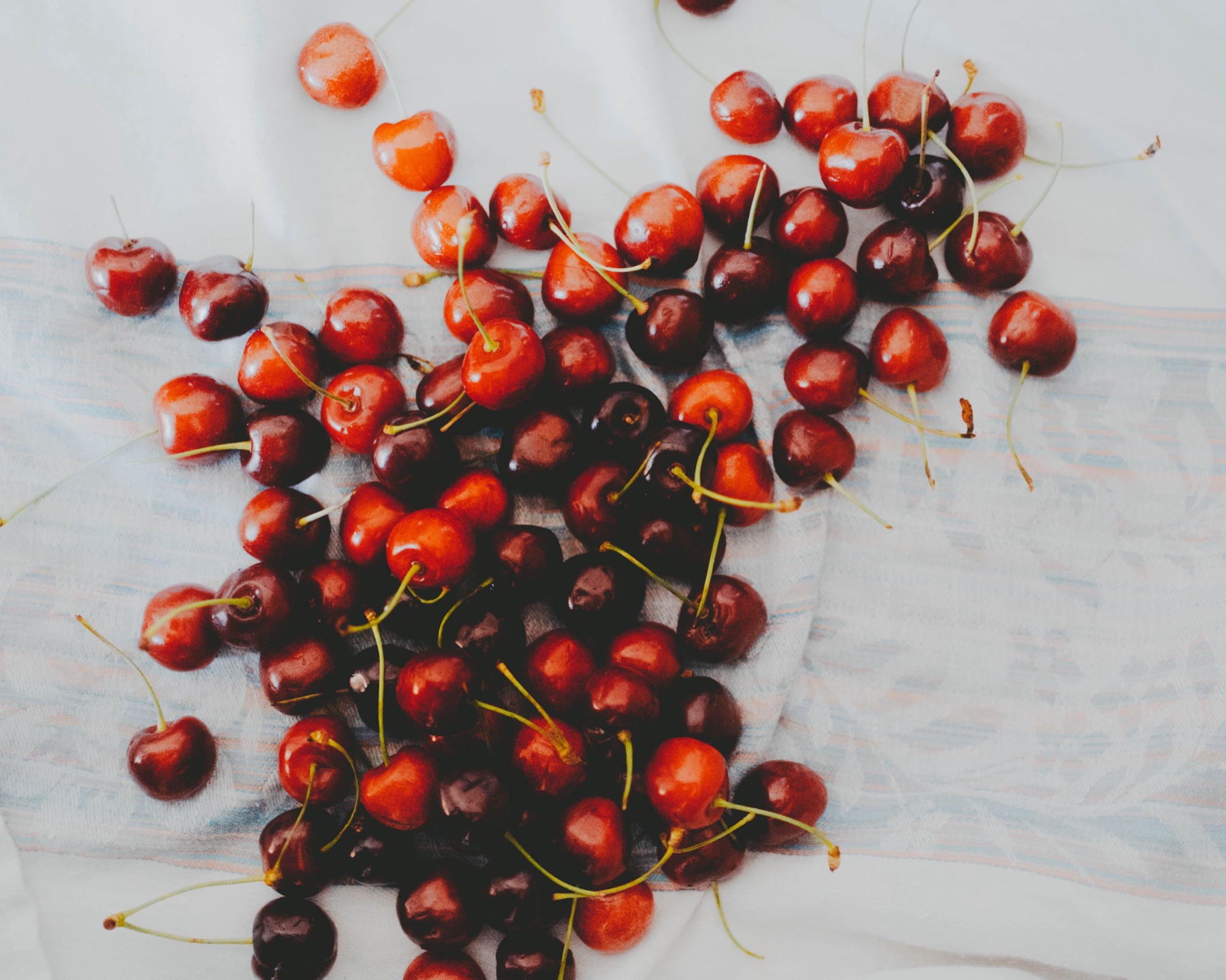 Red berries scattered across pale cloth