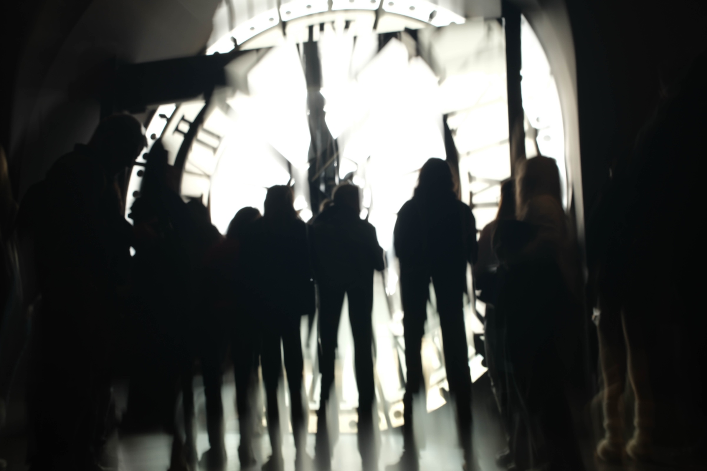 Silhouetted people crossing a bright modern interior