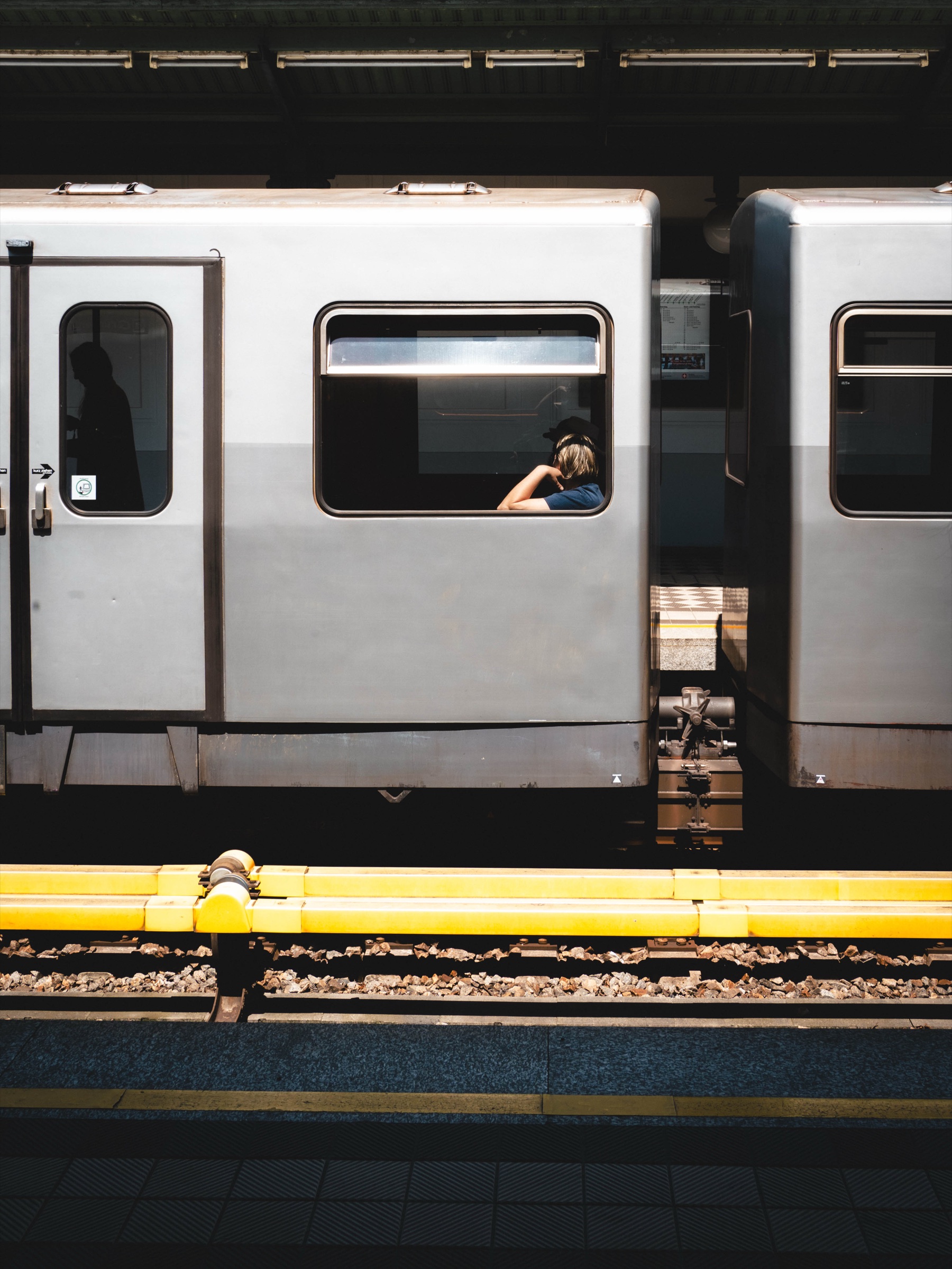 A yellow bench on a dark urban train platform